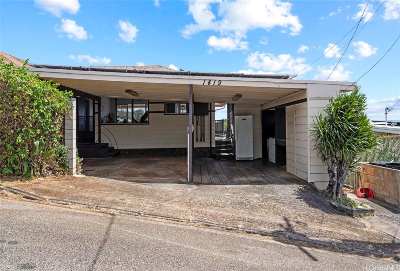 Carport with entrance to the first level and stairs down to the lower levels