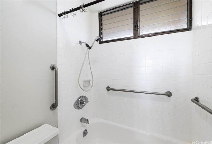 Bathroom featuring grab bars and newly refurbished tub