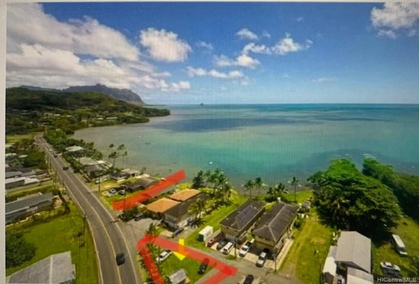 The triangle lot has a low rock wall on the highway side and a storage building on a foundation on the lot.  The red line in this picture is the plot of land that has access to the ocean and it is included in this sale.