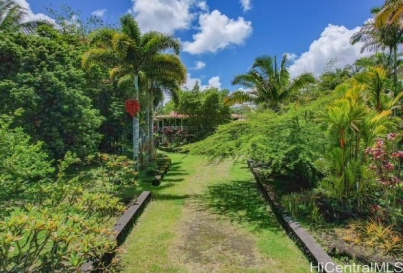 grass driveway lined with a low rock wall