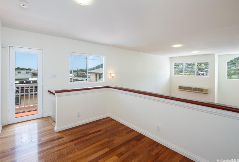 Upstairs you'll find an office/den, primary bedroom and bath, this landing area for a possible reading area.  The door opens out to a small balcony overlooking the pool