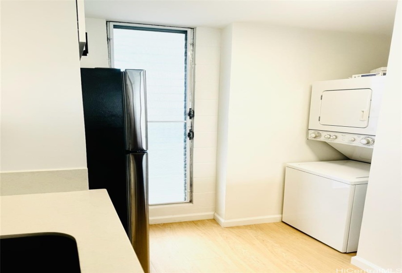 Stacked washer/dryer in unit is smartly tucked away behind the pantry closet for utility and clean visual appeal. New flooring runs completely beneath the W/D to the wall.