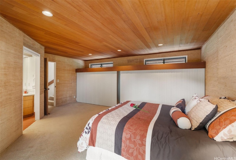 Main bedroom with redwood ceilings, slider to the concrete patio and wood deck outside.