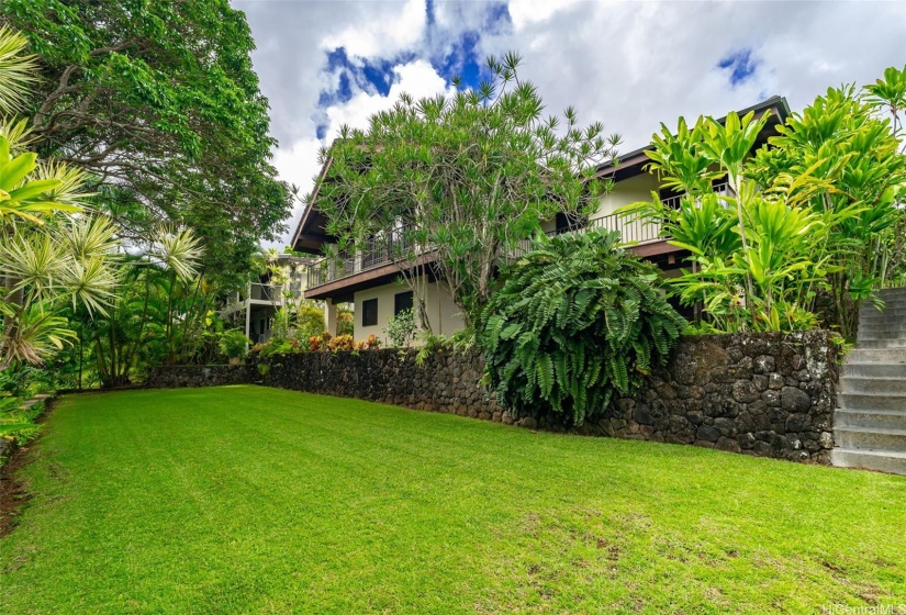 Rear yard and rock walls.  Steps to right go to main bedroom and continue to upper yard of home