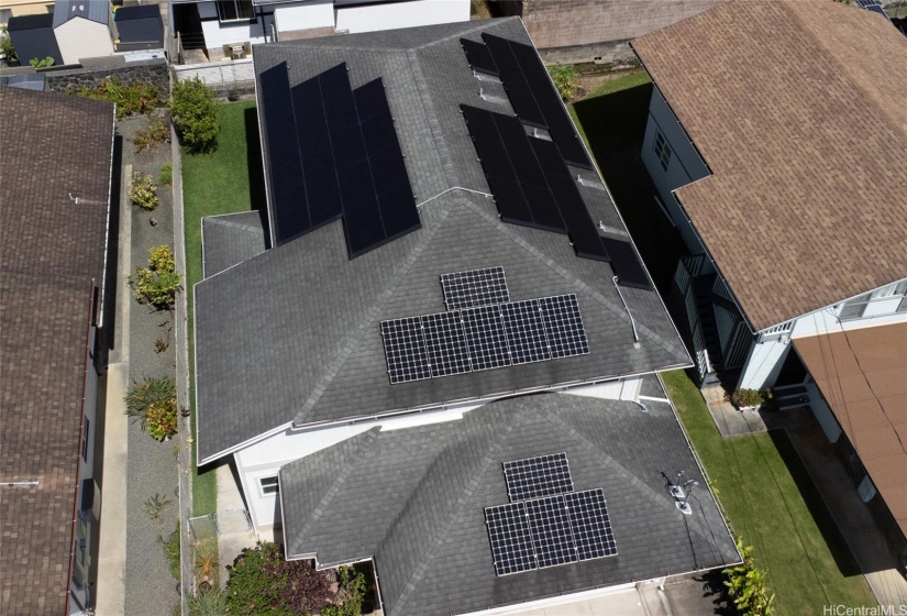 An aerial view of the home showcases its 36 fully-owned photovoltaic panels and solar water system, highlighting its energy-efficient features.