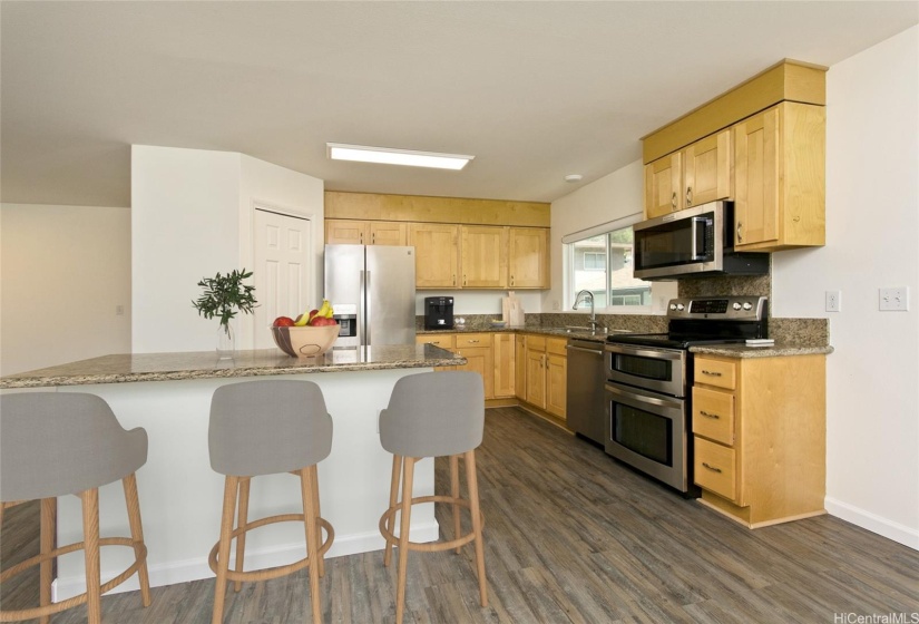 The open-concept kitchen provides plenty of storage and includes a spacious walk-in pantry for extra convenience. Photo is virtually staged.