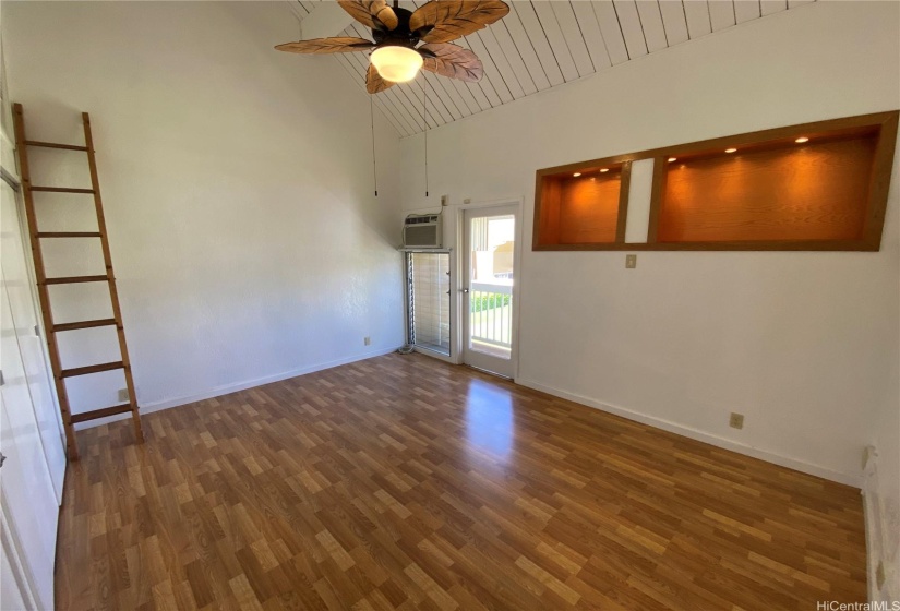 Master bedroom with ladder to access storage loft