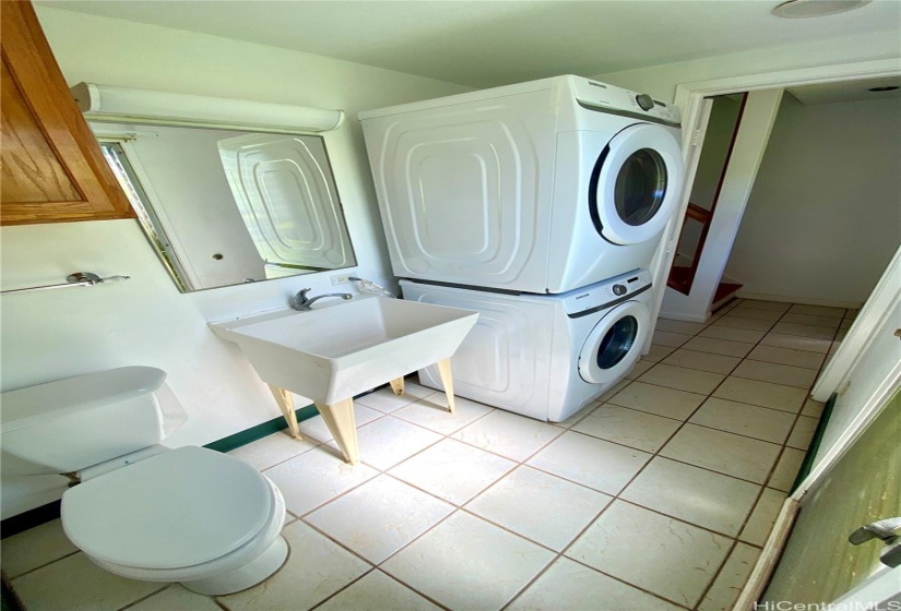 1/2 bath downstairs with stacked washer/dryer, toilet & utility sink