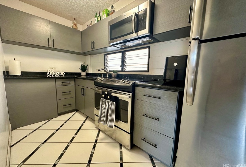 Sleek kitchen with stainless steel appliances.  Lots of cabinet storage above and below.