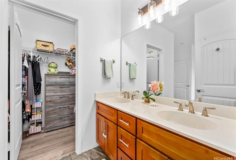 Primary bath with dual vanity and extended closet.