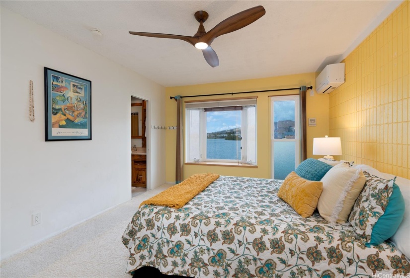 Upstairs primary bedroom with Bay window looking provides views towards sunset and the water.