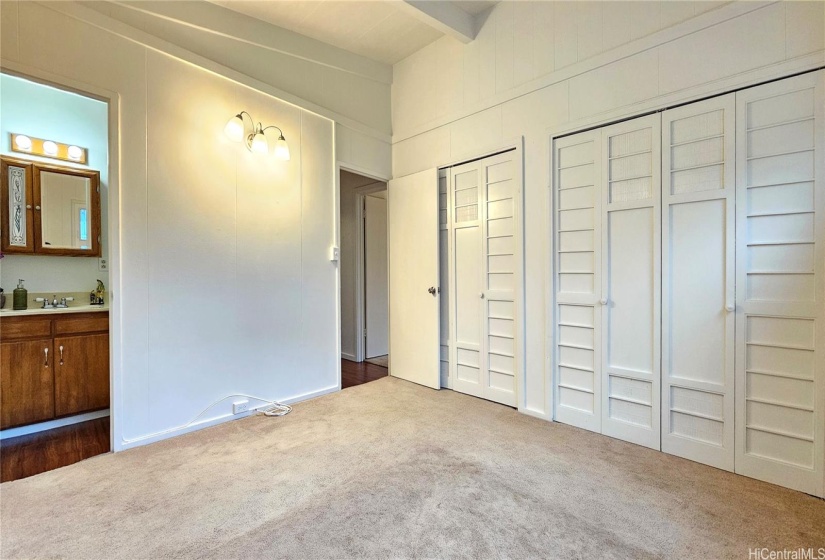 The master bedroom has open beam ceilings and a half bath with double closets.