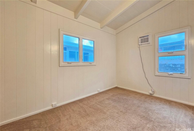 Corner bedroom with open beam ceilings, AC, vinyl awning windows and carpet.