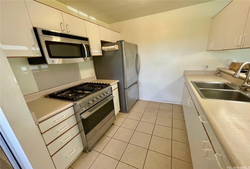 The kitchen features newer appliances and a gas stove.