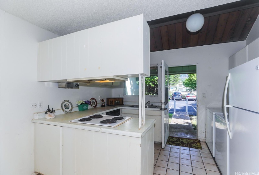 Kitchen entry with ceramic tile floors with the laundry area on  the right