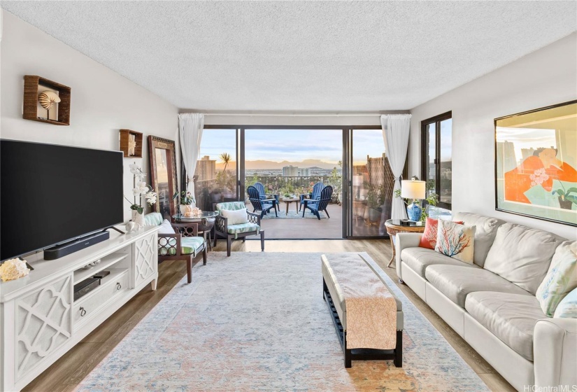 The expansive 350-square-foot lanai, living area, and primary bedroom offer sweeping city and mountain vistas along with peek-a-boo ocean views, making for a breathtaking sunset experience all year round!