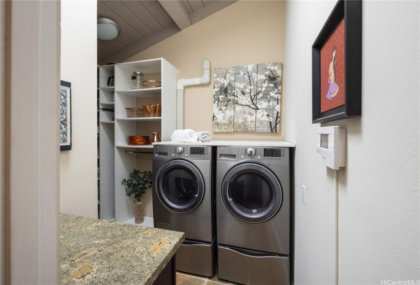 Large pantry and laundry room has vaulted high ceiling with sky light