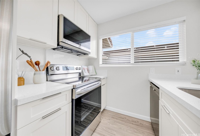 Modern kitchen with stainless steel appliances and custom built pantry.