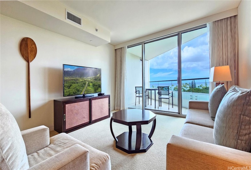 Spacious living room with covered lanai with beautiful view. You can enjoy the greenery from the park and the blue ocean even sitting in the living room sofa. Very relaxing and comfortable.