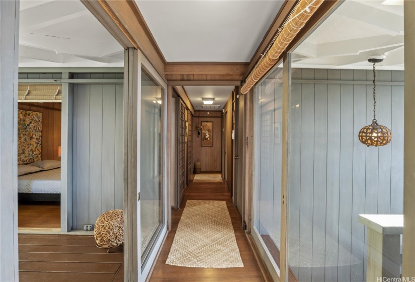 Hallway lined by sliding glass doors.