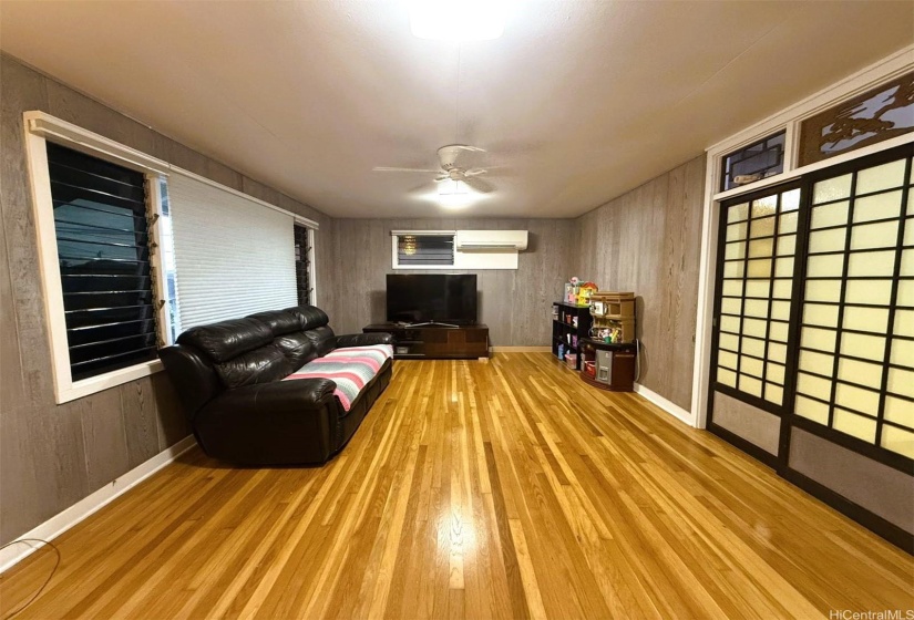 Nice spacious living room with polished hardwood floor and red wood wall.