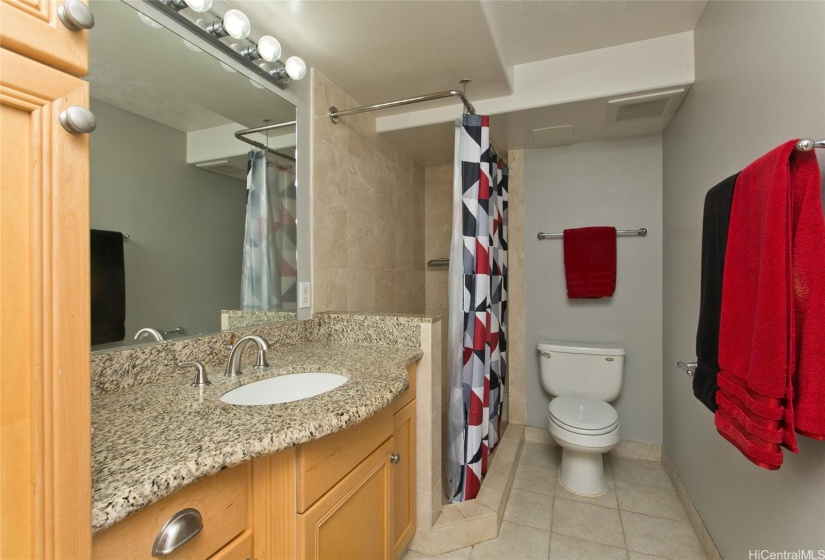 The bathroom features a shower stall and ceramic tile flooring.