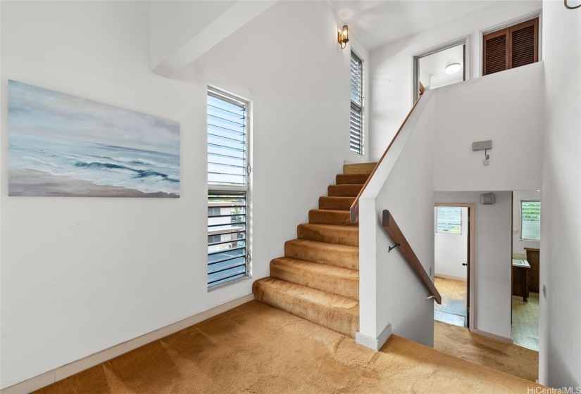 Stairs leading up to the 2 upper level bedrooms including 1 bath and loft area.