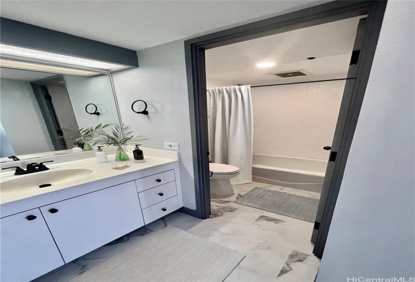 Large bathroom with separate Toilet and Bathtub area.Virtually staged