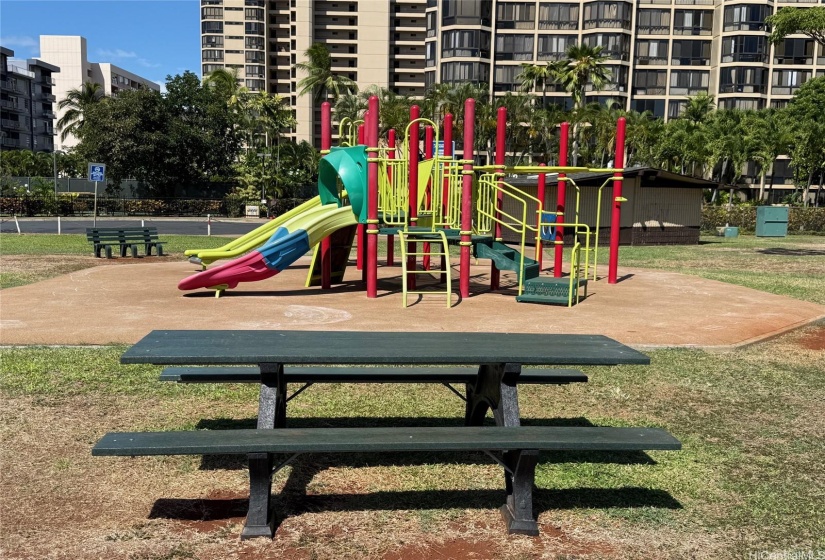 One of many picnic tables near the playground set at Hoa Aloha Neighborhood Park.  The bathrooms are in the background, behind the playground set.