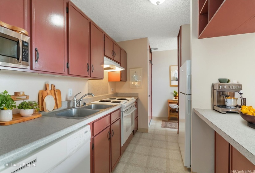 Virtually Staged - actual unit does not have a microwave.  The pass-through kitchen features copious counter and cabinet space with counter between the kitchen and living room for convenient dining.