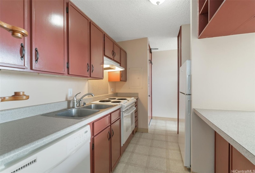 The pass-through kitchen features copious counter and cabinet space with counter between the kitchen and living room for convenient dining.