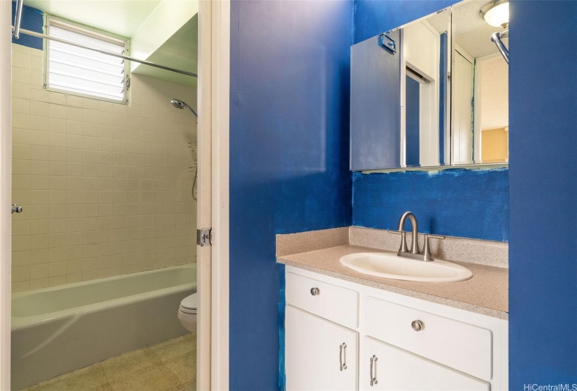 Bathroom area conveniently located right outside the bedroom so guests don't have to pass through the bedroom for access.  The sink and vanity are separate from the tub/shower with sliding door between.