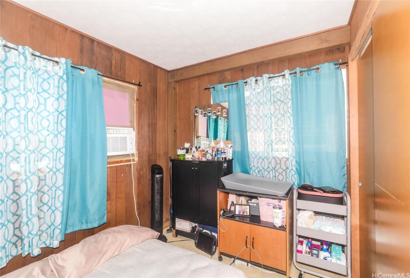 Bedroom with wood paneling on all walls