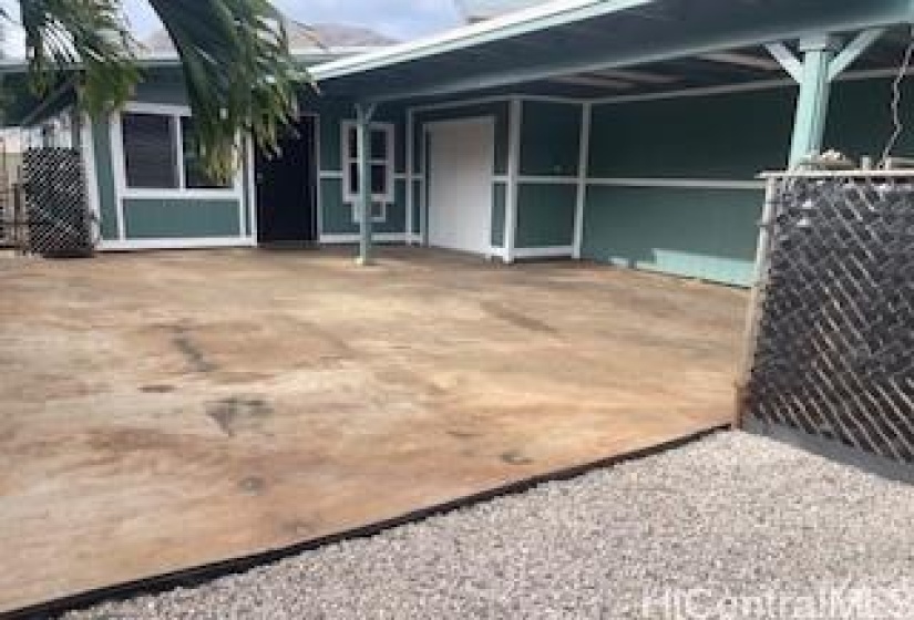 Extra pad on the side of the carport for entertaining or an additional parking spot.