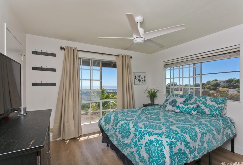 Primary bedroom features windows on both walls - letting in cool breezes and beautiful natural light