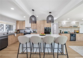 Dream Kitchen with Luxurious Finishes! Custom Lighting, Island Dining with Waterfall Countertops. Impeccable Quality White Oak Kitchen Cabinets show off the Tasteful Design & Functionality of the Space!