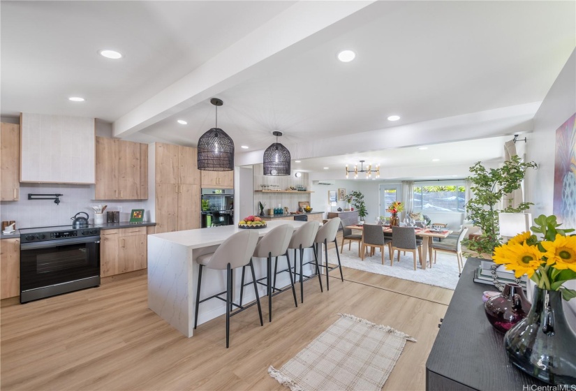 Spacious layout with a central island, perfect for entertaining, highlighted by black pendant lights and natural light.
