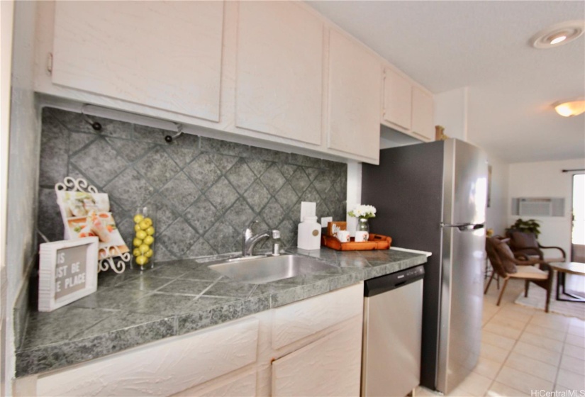 Kitchen w/ a slate type tile counter & backsplash