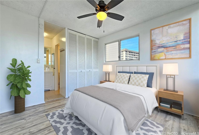 Virtually staged(enhanced). Primary bedroom w/ double closet, jalousie windows, and vinyl plank