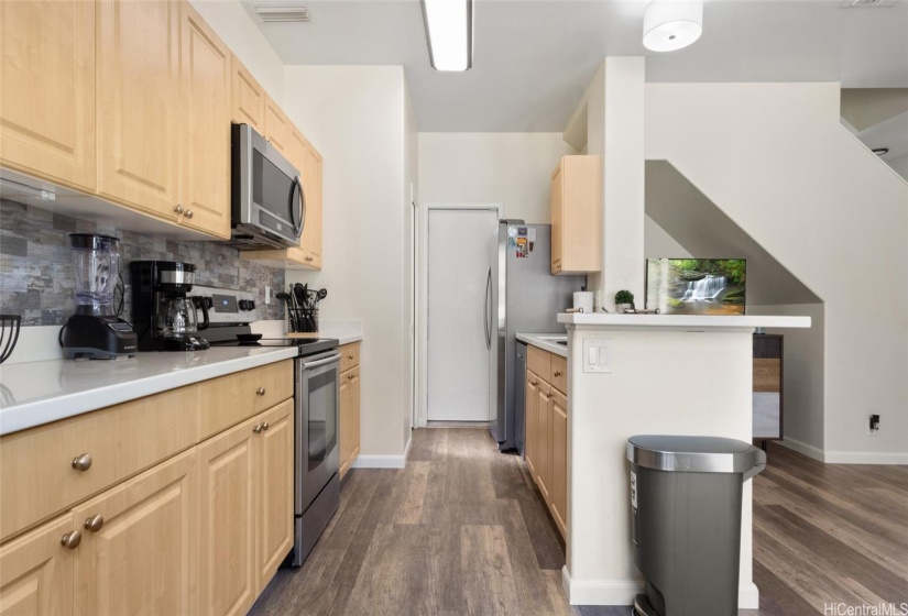 Gourmet Kitchen with Stainless Steel Appliances, half bathroom, and garage door access.