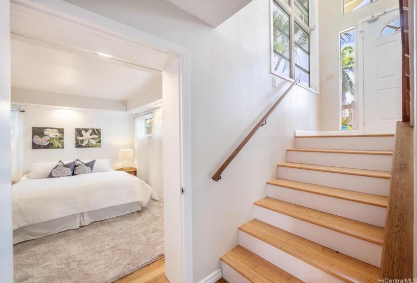 The internal staircase connects the upstairs 3/2 to the downstairs 1/1 unit. Access to the garage is to the right. There is also storage under the stairs.