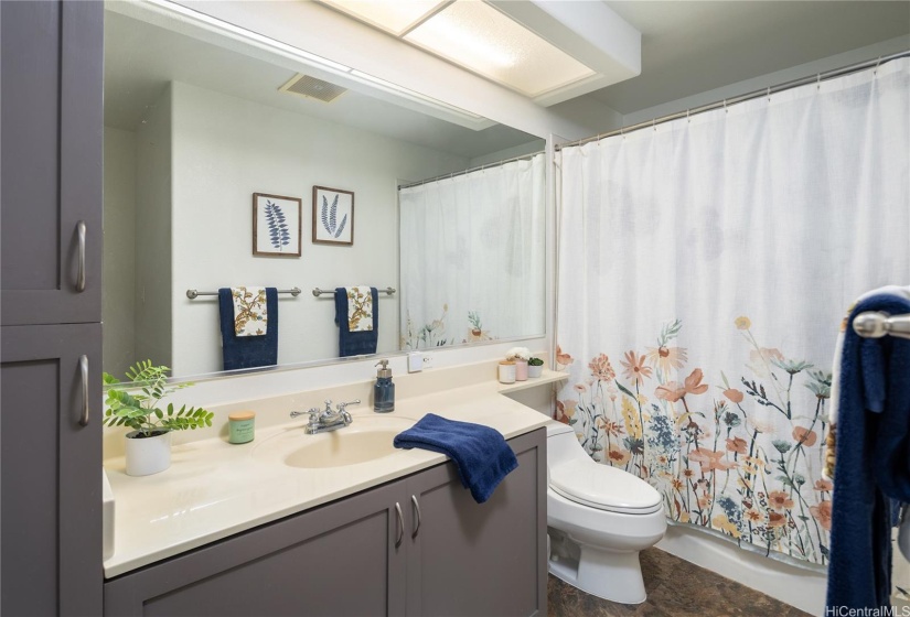 Spacious bathroom has a full sized tub and a linen closet inside.
