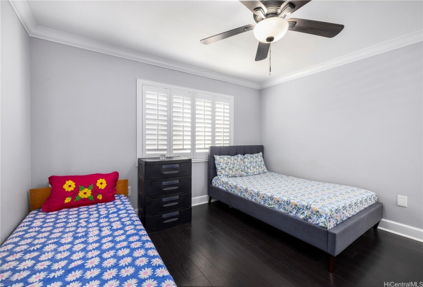 Bedroom with 2 twin size bed and window plantation shutters