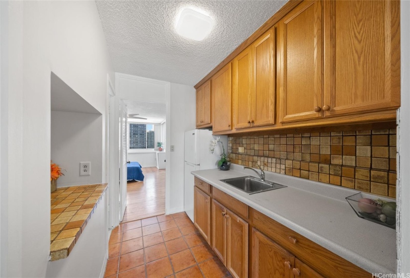 Ceramic tiling backsplash and ceramic tile flooring give this apartment character.