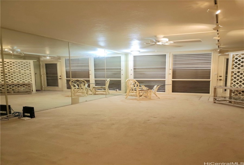 Living area looking from the kitchen towards the front door. Mirrored wall on left.