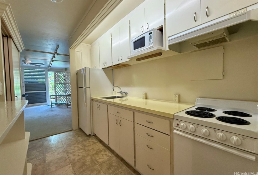 Kitchen towards living area. Apartment-sized range/oven.