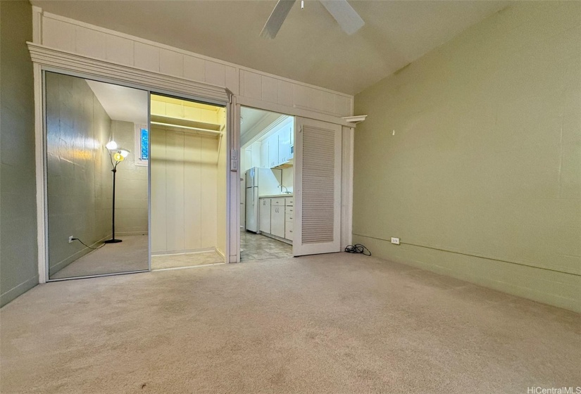 Bedroom with mirrored sliding doors on the closet. There is also nice lighting in the closet.