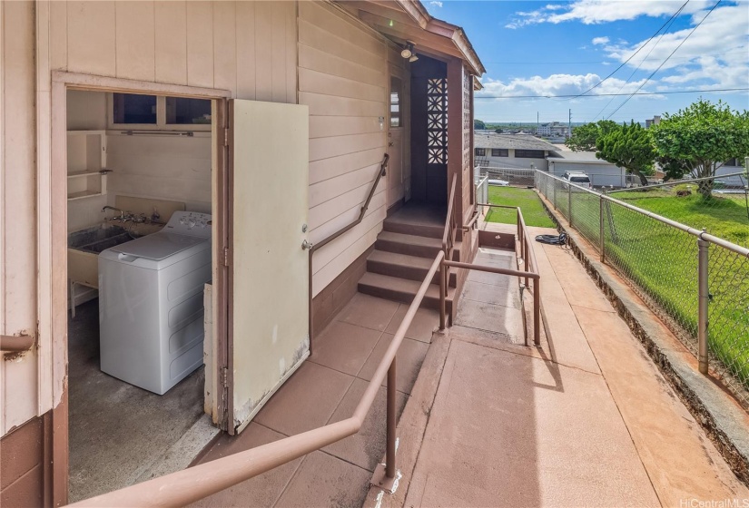 Left side of the house has an entry to the kitchen and a covered laundry room with a full bathroom.