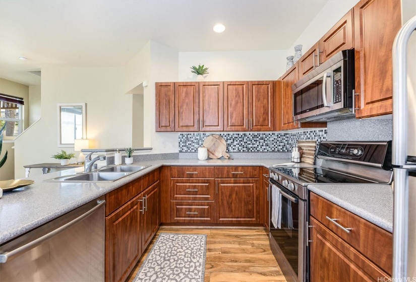 Stylish kitchen with tile backsplash & stainless steel appliances.