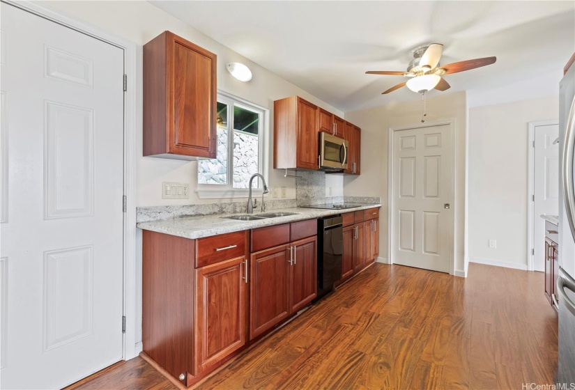 Kitchen and pantry with a pocket door. Stainless steel fridge and Jenn-air double oven